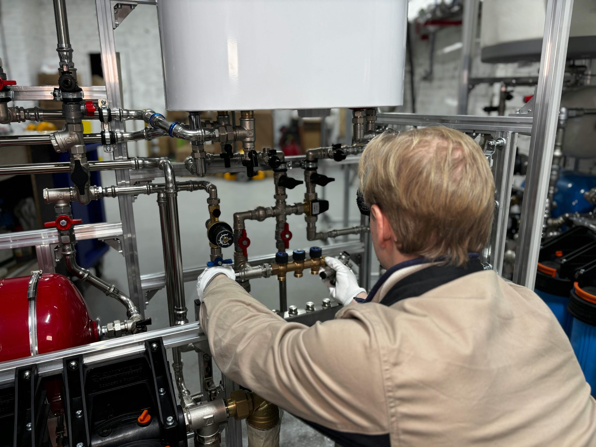 Ingénieur travaillant sur un système de tuyauterie industrielle dans une usine, pour le réglage du chauffage et de la production.